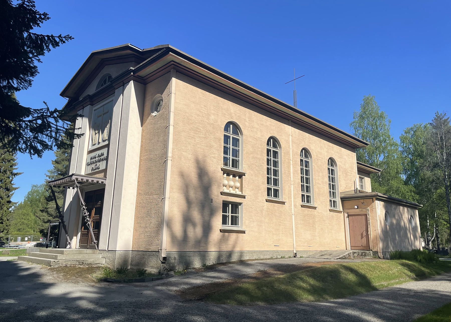 Rauhankappeli Vaalea rakennus, jossa suuret sivuikkunat.