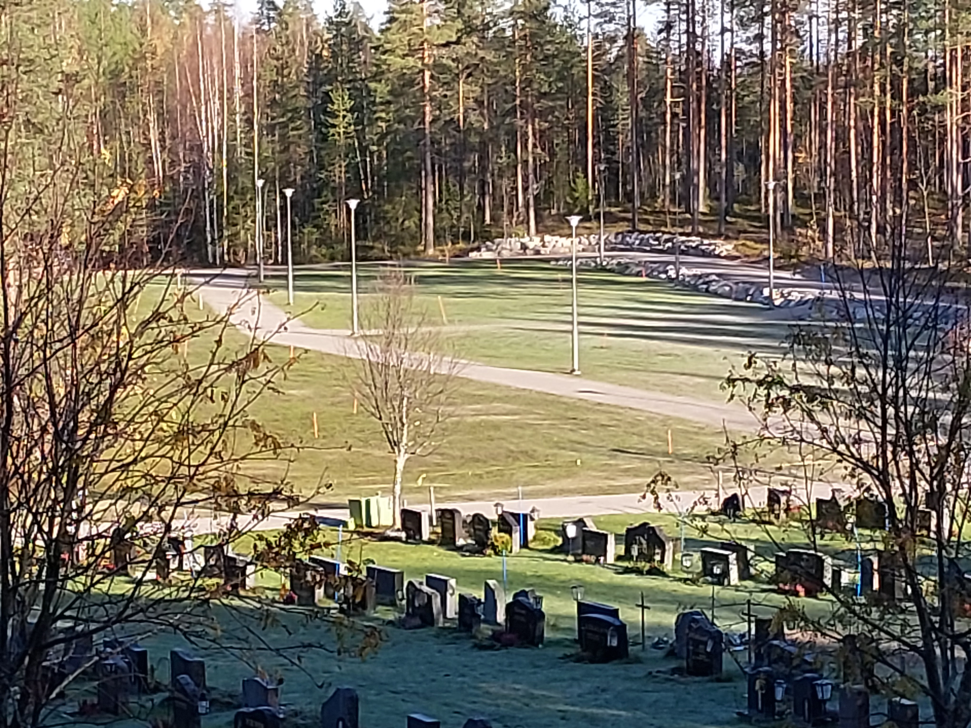Etualalla hautausmaata ja hautakiviä riveissä, taka-alalla nurmialue, johon ei ole vielä hautoja kaivettu s...