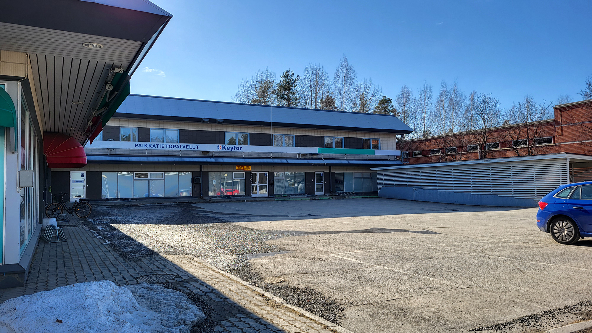 Toimistorakennus, jonka edessä parkkipaikka.