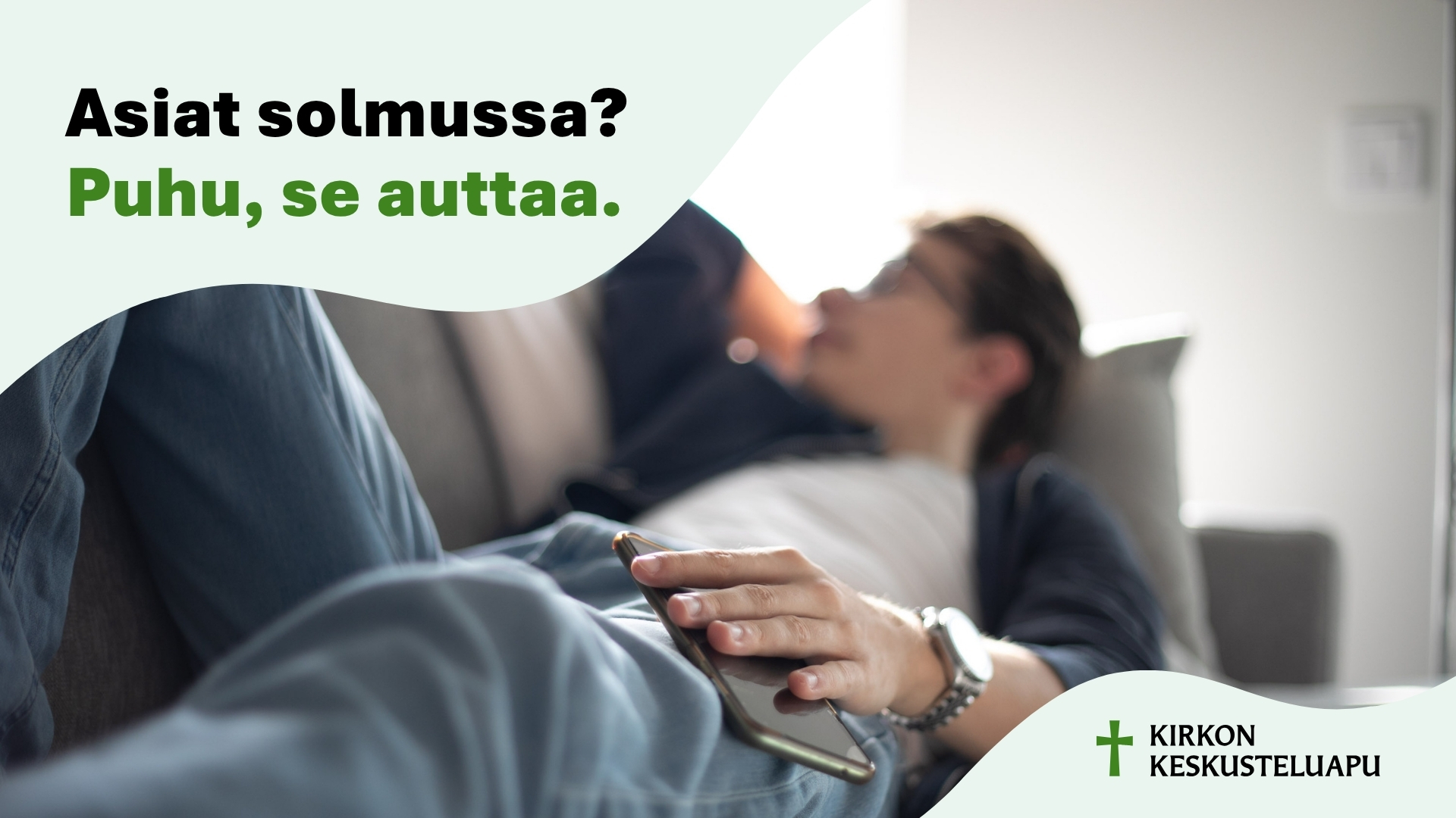 Ihminen makaa sohvalla. Hänen kädessään on puhelin. Yllä on teksti: Asiat solmussa? Puhu, se auttaa. Alla o...
