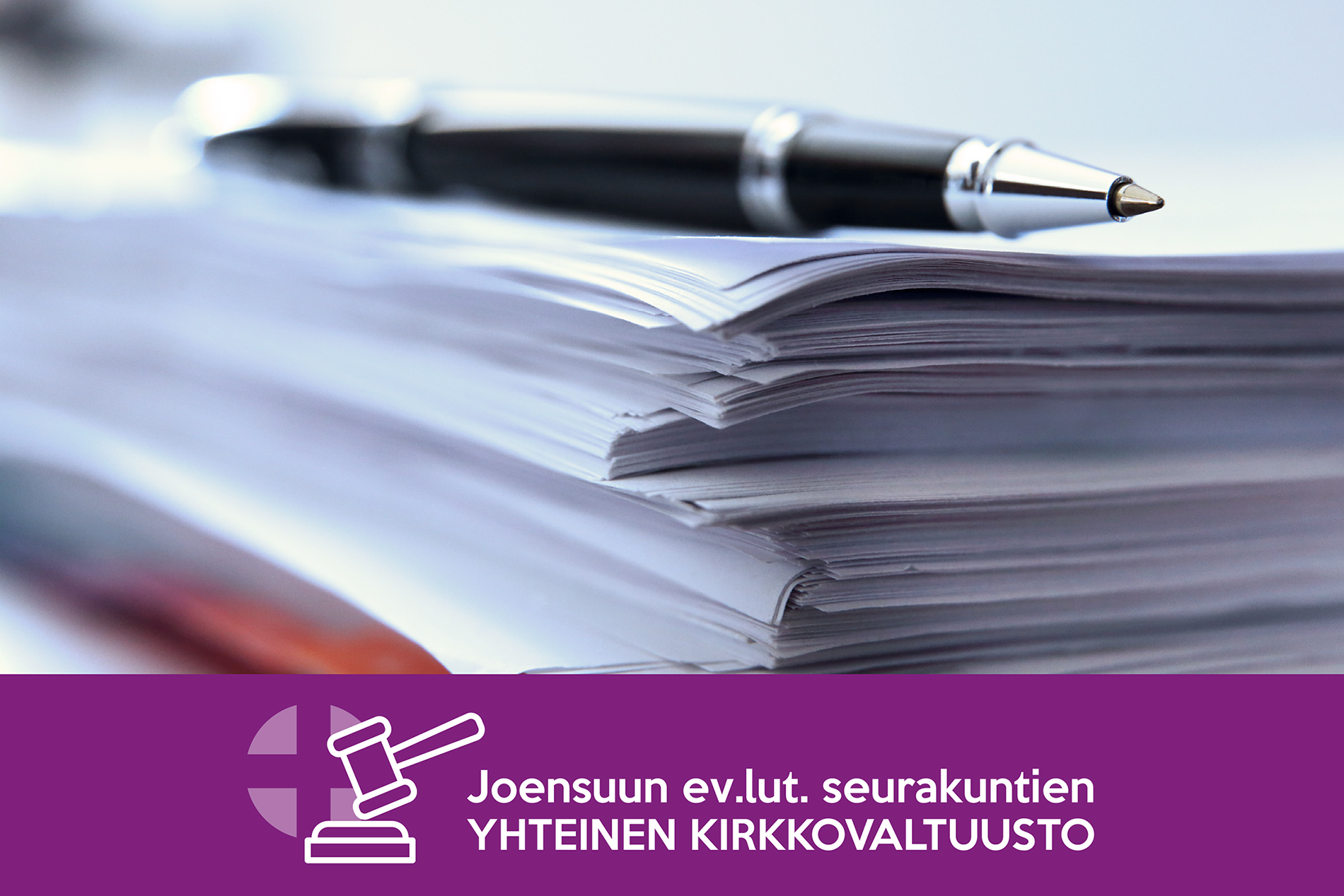 kynä paperipinon päällä