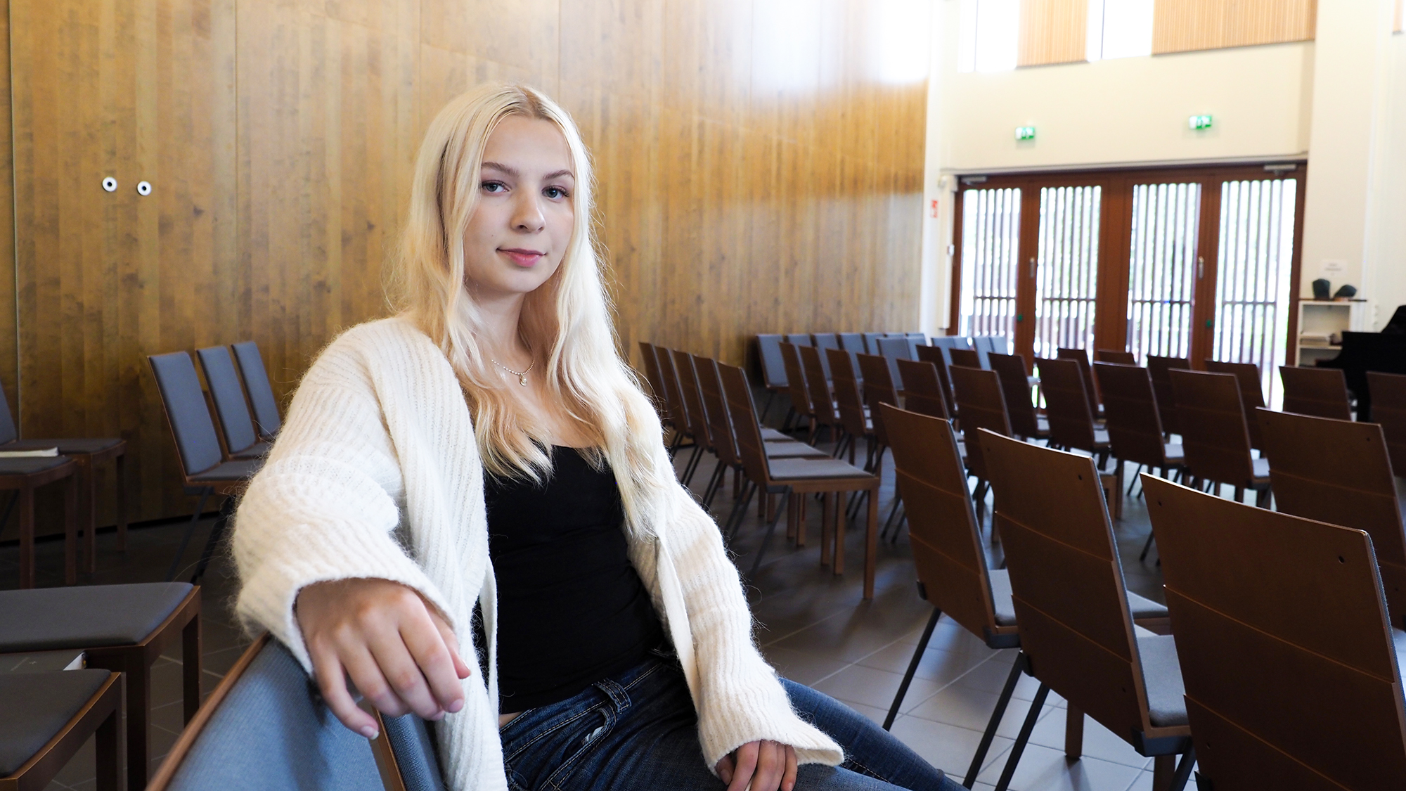 Minttu Termälä istuu penkillä ja pitää käsivarttaan toisen penkin selkänojalla.