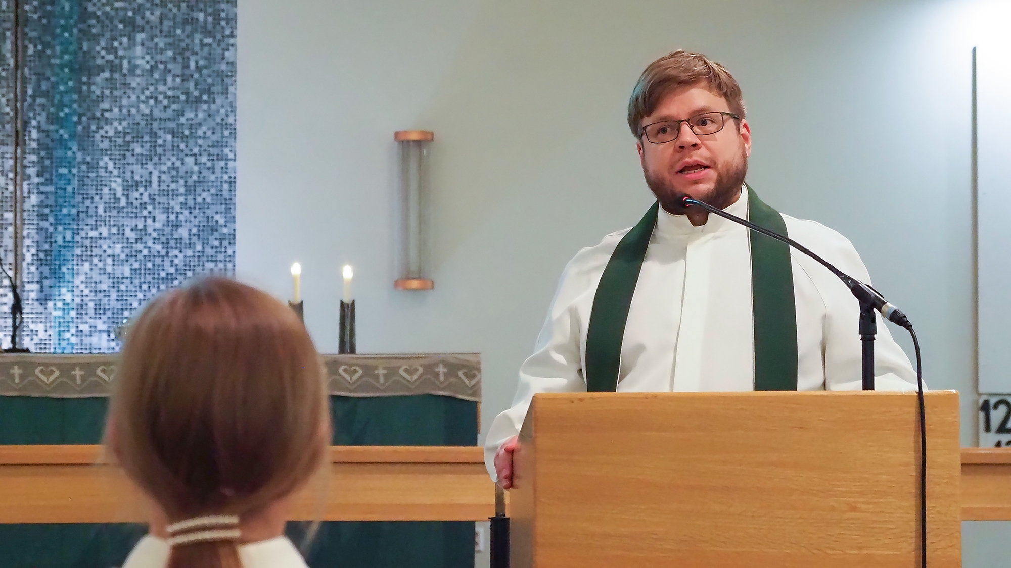 Antti Kyytsönen seisoo Pielisensuun kirkon lukupulpetin ääressä ja puhuu.