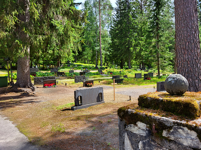 Kivinen portinpieli, hautamuistomerkkejä sekä puita.