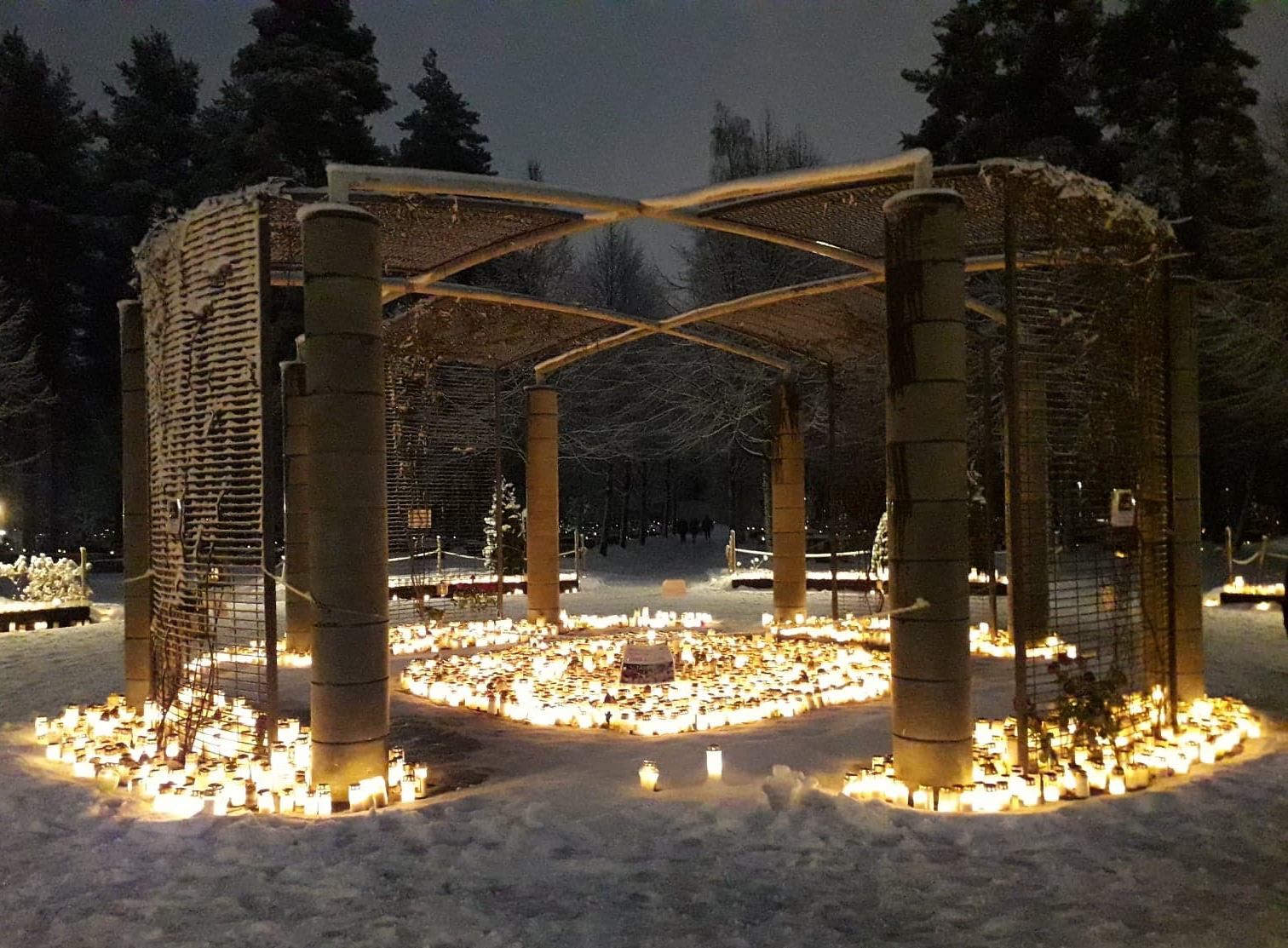 Kynttilöitä Joensuun hautausmaan muistelupaikalla illanhämärässä jouluna 2019.