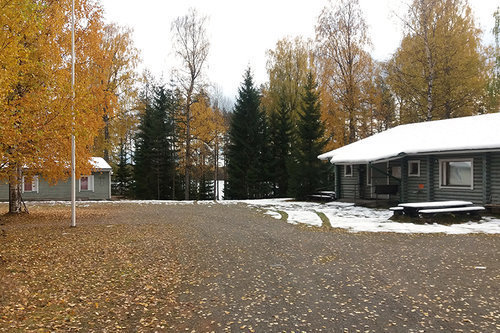 Loppusyksyinen kuva Hietajärven leirikeskuksen hirsisestä päärakennuksesta, pihapiiristä ja lisärakennuksesta.