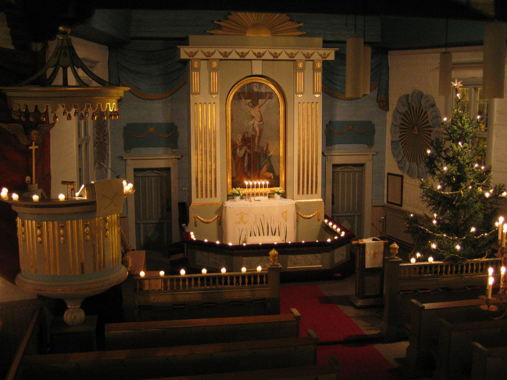 Kiihtelysvaaran kirkko sisältä jouluna, kirkossa on paljon kynttilöitä ja joulukuusi