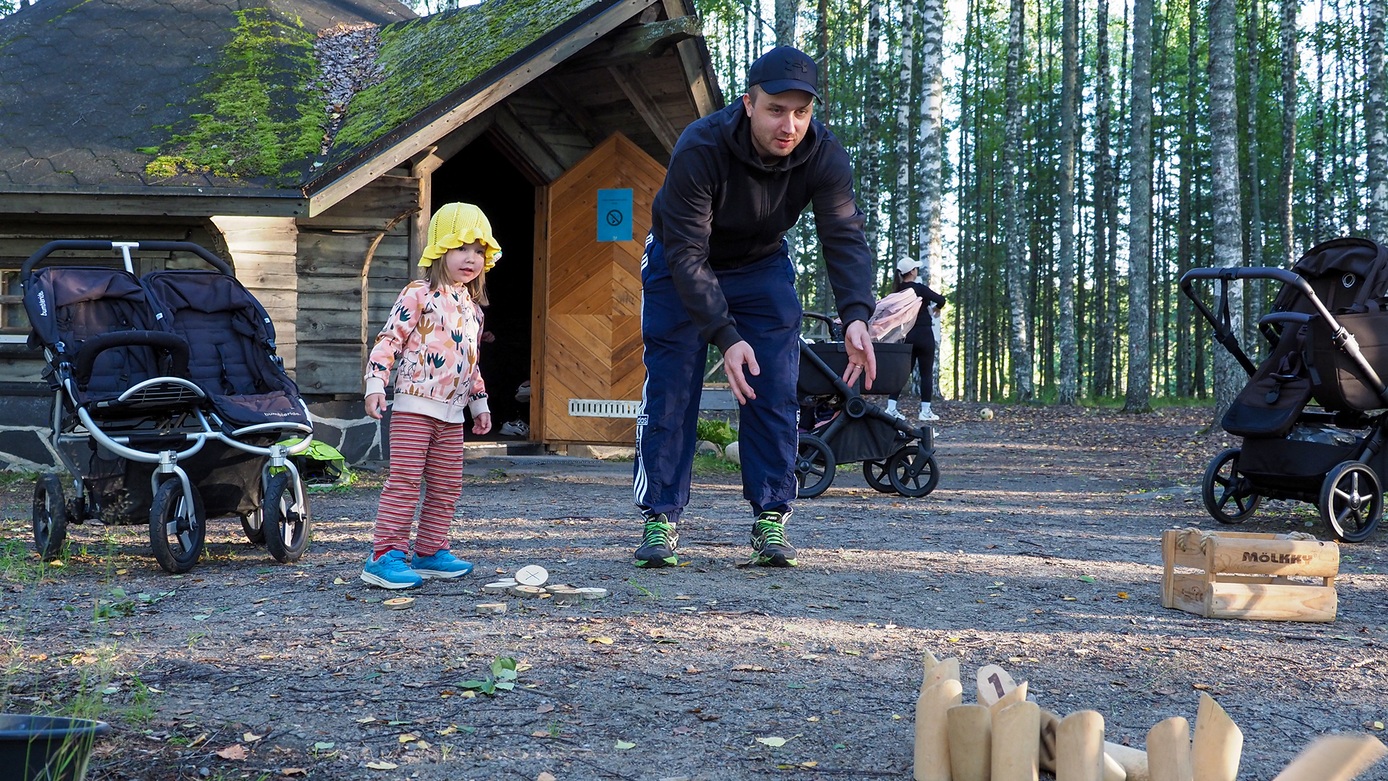 Helmi ja Mikko Noponen heittävät mölkkyä Utransaaren kodan edustalla.