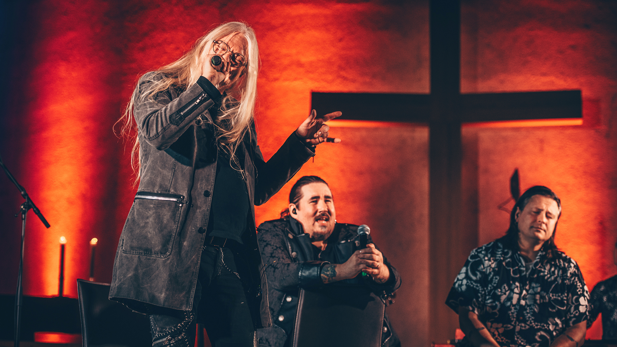 Marko Hietala laulaa. Taustalla näkyy suurikokoinen risti.
