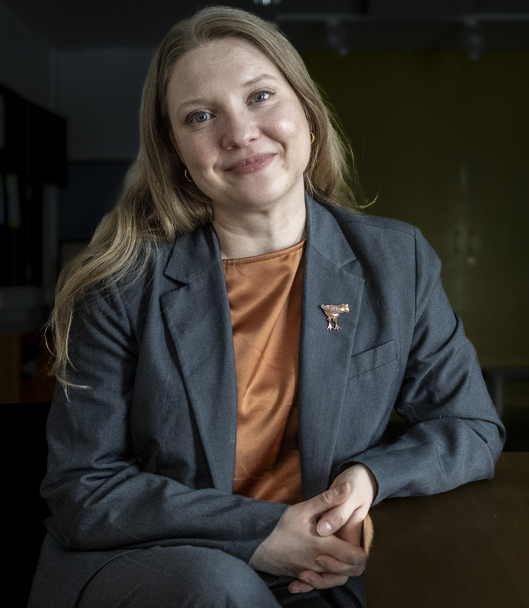 Suvi Tuuli Karhu istuu ja nojaa toisella kädellään pöytään.